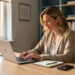 Une consultante organise sa routine quotidienne de prospection dans un bureau de conseil, avec un ordinateur portable, un carnet et un smartphone.